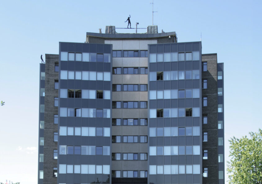 Hochhaus mit vielen Fenstern umgeben von blauen Himmel
